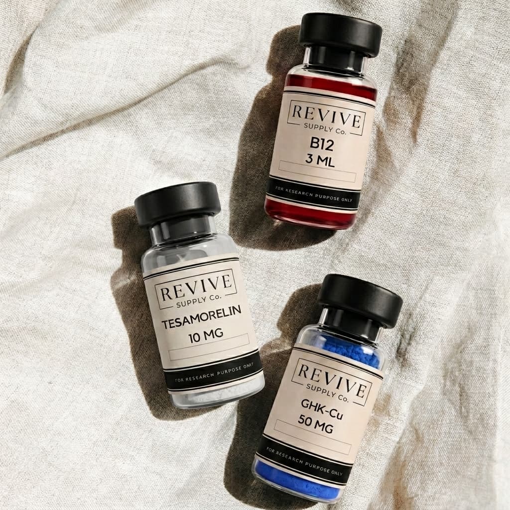 Revive B12, Tesamorelin, and GHK-Cu vials arranged on natural linen